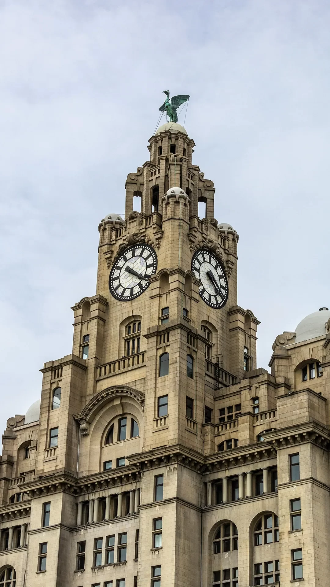 A shot of one of The Royal Liver Building's clock towers on a clear and overcast day.